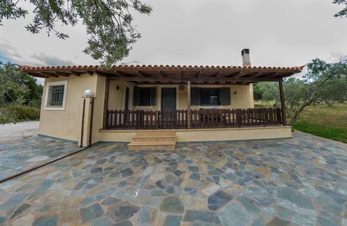 Porto Heli Cottage | A detached house which is embraced by green trees and beautiful flowers.